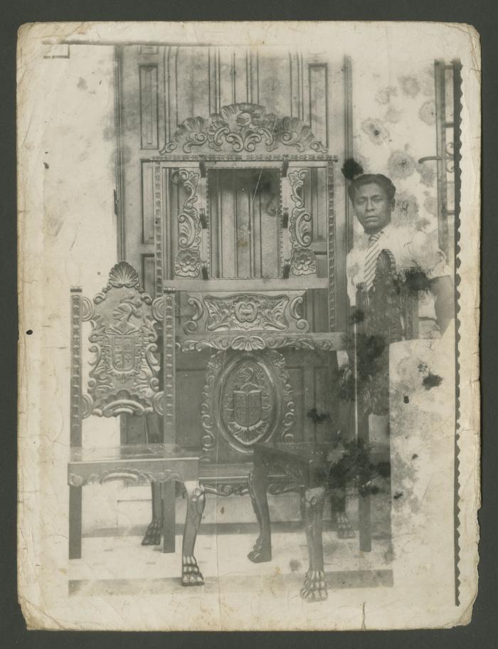 Humberto Mansilla posa junto a dos sillas y vano tallados