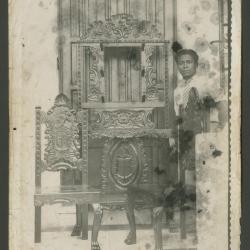 Humberto Mansilla posa junto a dos sillas y vano tallados